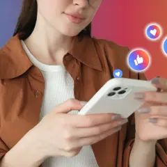 Kobieta z telefonem, wokół niej serduszka i kciuki w górę – idealny przykład viral marketing.