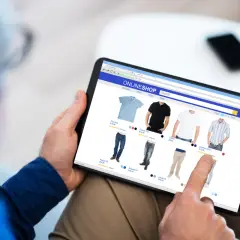 Mężczyzna przegląda ubrania w sklepie internetowym, korzystając z nawigacji fasetowej, aby znaleźć idealny produkt.