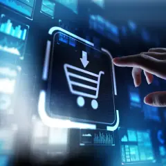 Dłoń dotyka ikony koszyka na ekranie, symbolizując zakupy online i rozwój e-commerce.
