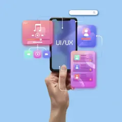 Dłoń trzyma smartfon z napisem UI/UX. Wokół telefonu widoczne są kolorowe elementy interfejsu, sugerujące audyt UX i projektowanie aplikacji.