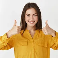 Uśmiechnięta kobieta w żółtej koszuli pokazuje kciuki w górę, symbolizując sukces w **referral marketing**.