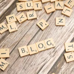 Litery układają się w słowo BLOG, sugerując, jak założyć bloga i zarabiać.