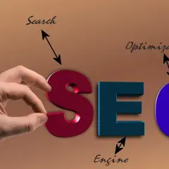 Ręka układa literę "S" w napis SEO, symbolizując usługę optymalizacji dla wyszukiwarek.