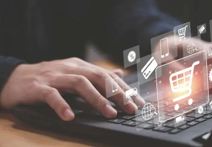Dłoń na klawiaturze laptopa, ikony koszyka, karty i procentów symbolizują pozycjonowanie Magento i e-commerce.