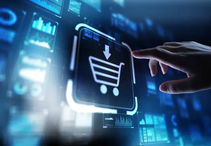 Dłoń dotyka ikony koszyka na ekranie, symbolizując zakupy online i rozwój e-commerce.