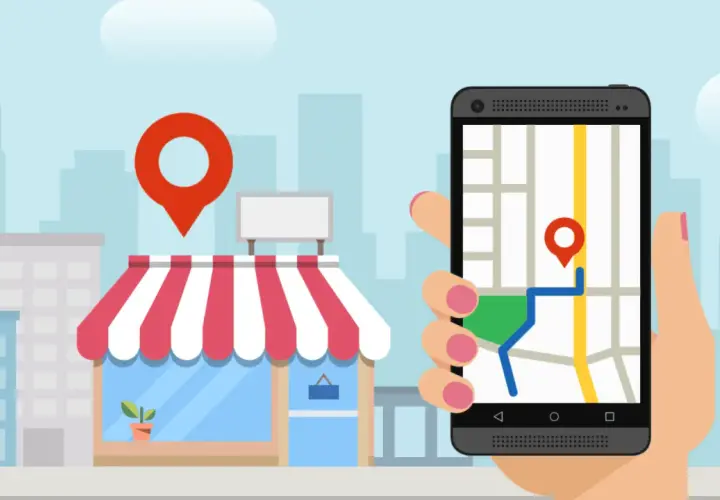Smartfon z mapą i pinezką pokazuje drogę do sklepu. To klucz do skutecznego pozycjonowania lokalnego.