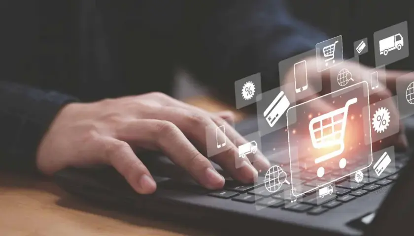 Dłoń na klawiaturze laptopa, ikony koszyka, karty i procentów symbolizują pozycjonowanie Magento i e-commerce.