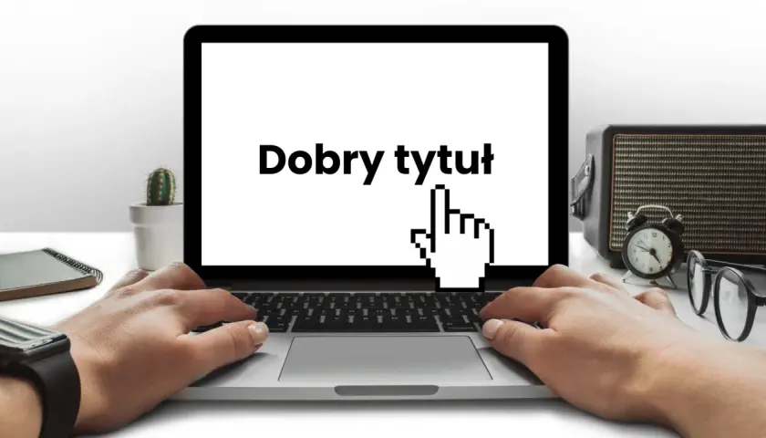 Ręce na klawiaturze laptopa, na ekranie napis "Dobry tytuł" i kursor myszy. Obok kaktus, radio i okulary.