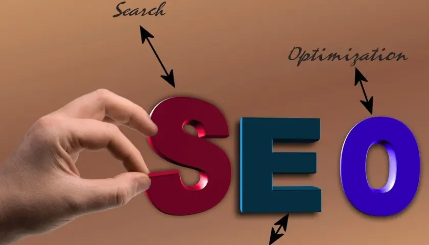 Ręka układa literę "S" w napis SEO, symbolizując usługę optymalizacji dla wyszukiwarek.