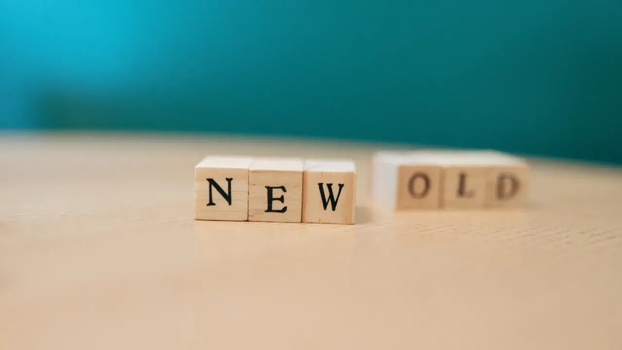 Drewniane klocki z napisami "NEW" i "OLD" na jasnym blacie. To jak archiwalna wersja strony, która pokazuje przejście od starego do nowego.