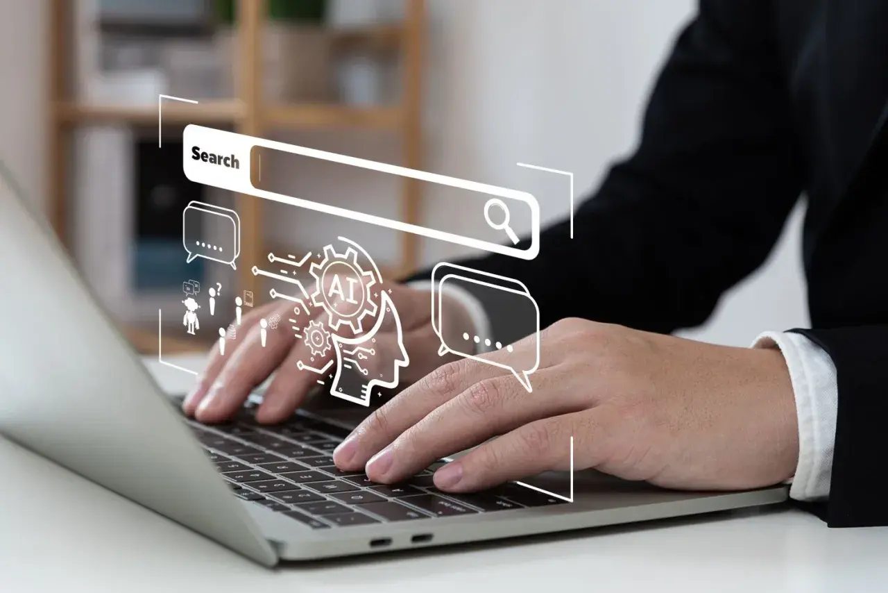 Osoba pracuje nad laptopem, nad którym wyświetla się grafika symbolizująca wyszukiwanie i sztuczną inteligencję, kluczowe elementy skutecznej strategii SEO.