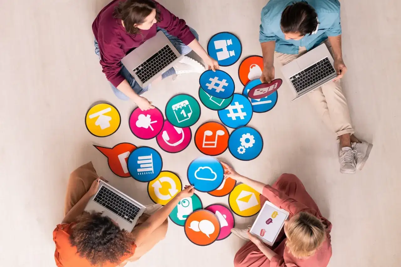 Zespół pracuje nad strategią digital marketing, otoczony ikonami symbolizującymi media społecznościowe i komunikację.